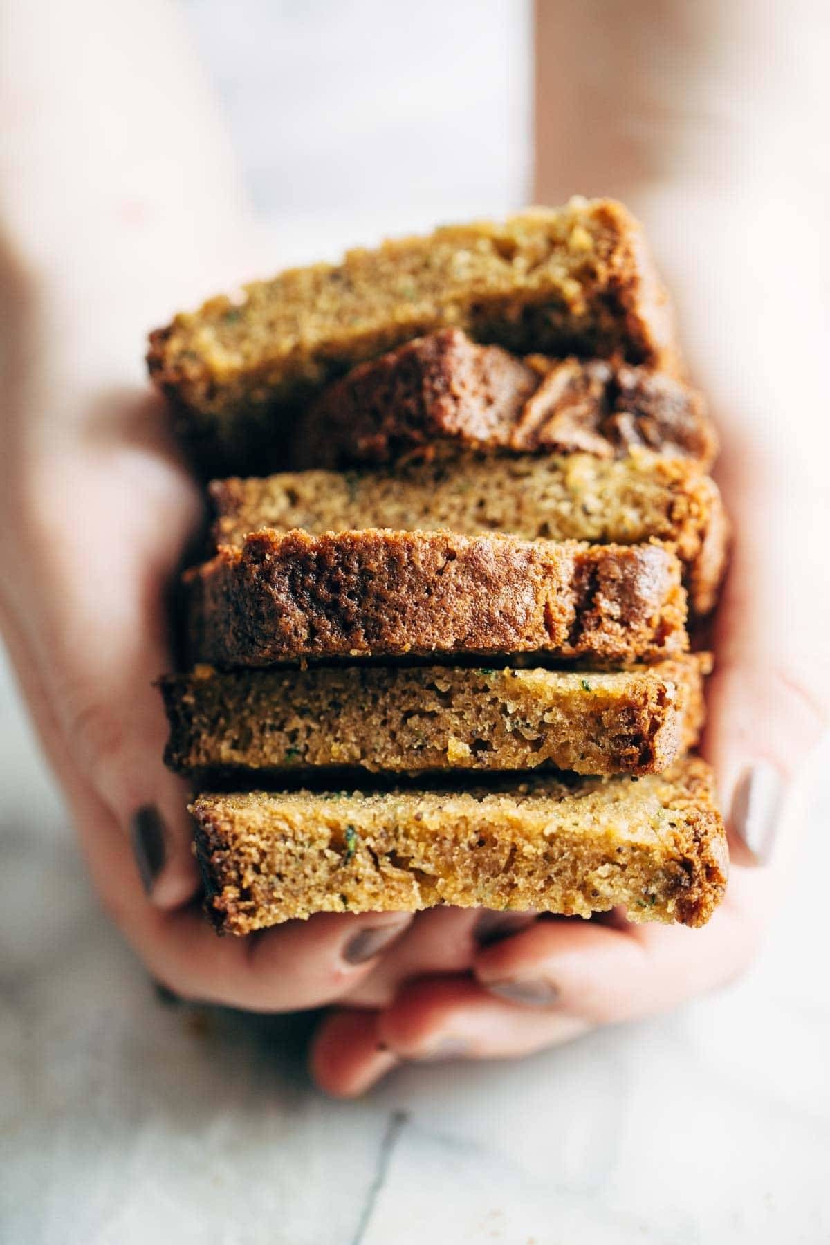 Hands holding lemon olive oil cake.