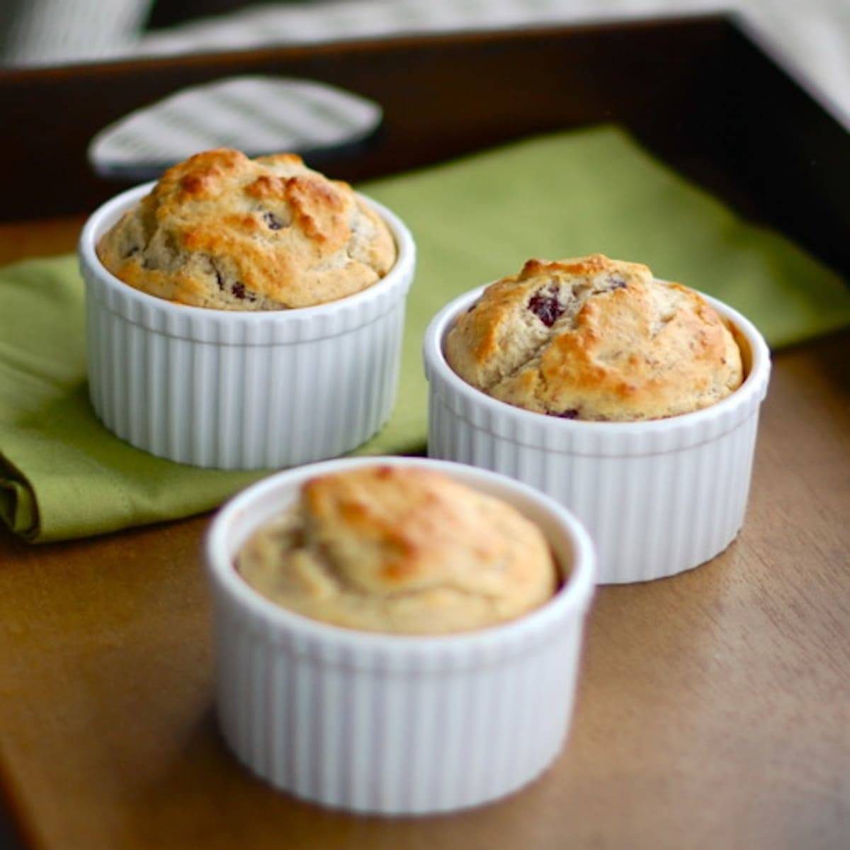 Three strawberry breakfast cakes in white dishes.